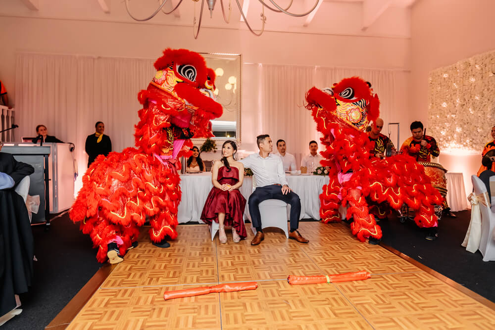 young bride and groom enjoying dancing dragons at oriental style wedding in Brisbane
